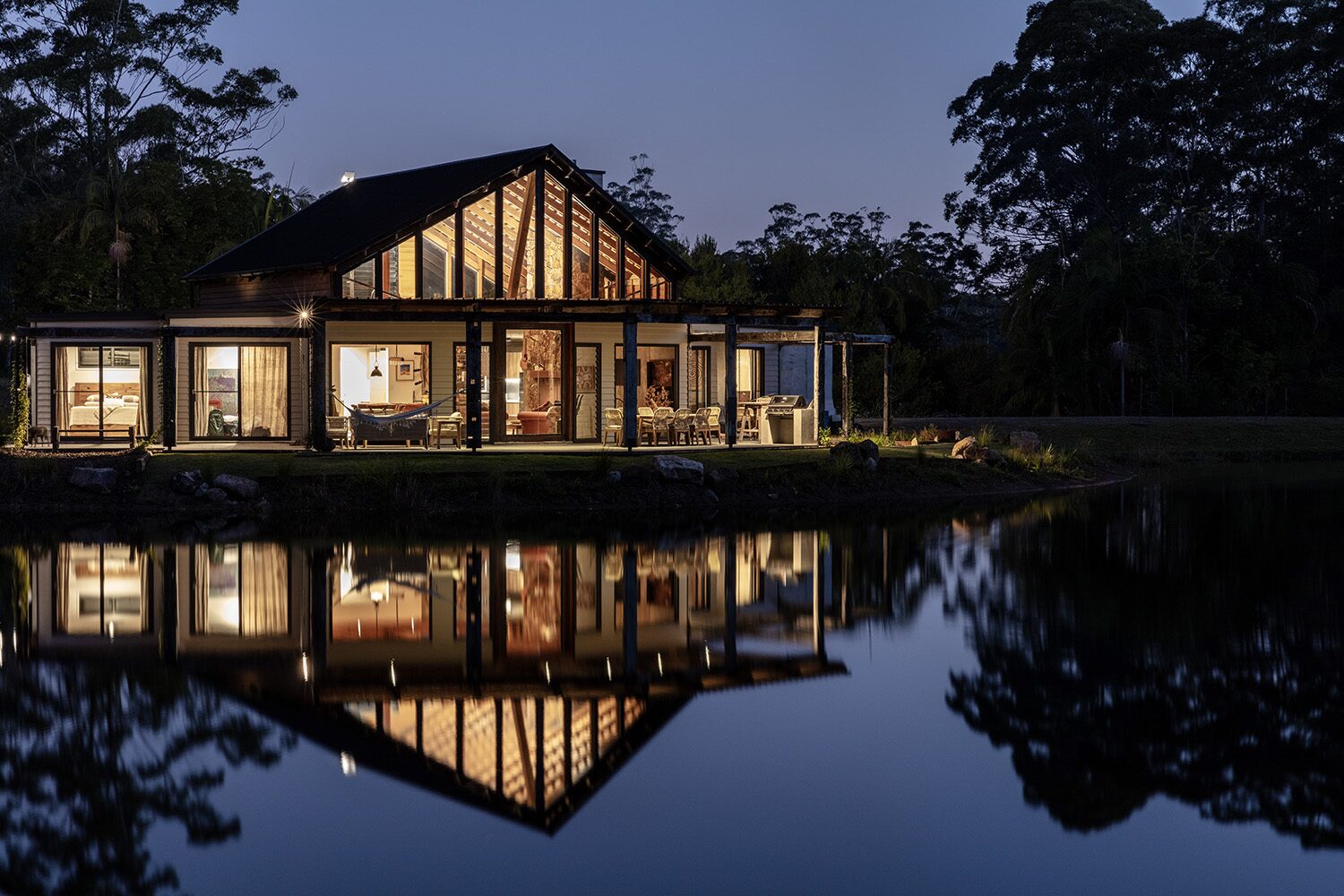 Arrowwood Acres, dusk facade and dam reflection — designed by Sprout Architects